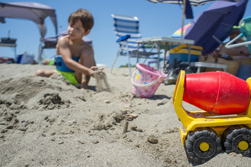 Little boy playing with sand and beach toys