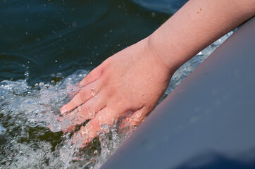 The hand is lowered into the water from an inflatable boat.