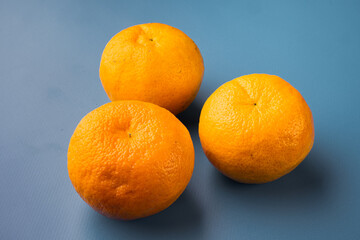 Organic clementine or tangerine, on blue textured summer background