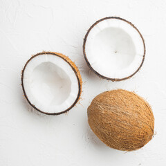 Fototapeta na wymiar Coconut halves, coconut pieces, on white stone table background, square format, top view flat lay