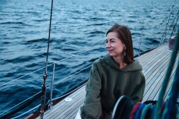 Joyful woman middle age portrait on deck of sailing yacht enjoying water trip