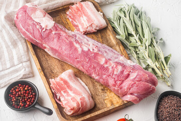 Organic pork fillet with ingredients and herbs for grill or baking, sage, potatoe, on wooden tray,...