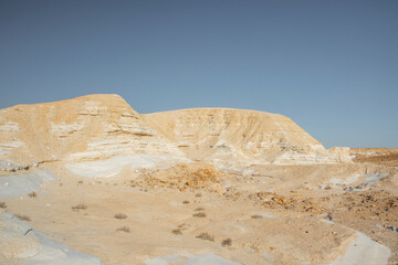 Beautiful lunar landscape. Wight and smooth hills in various shapes in a desert landscape. The whitish, rounded, winding, and smooth chalk rocks. Israel. High quality photo