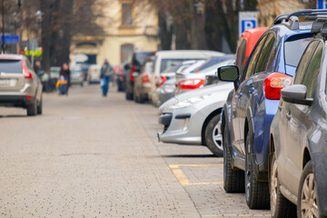 Fototapeta na wymiar Cars parked in a row on a city street side.