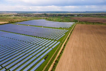 Aerial view of big sustainable electric power plant with many rows of solar photovoltaic panels for...