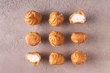 Profiteroles lie on a gray textured background.