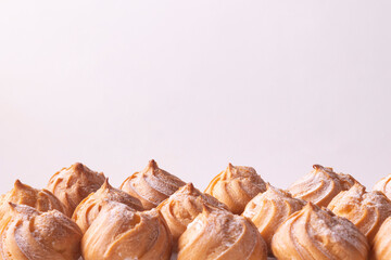 Tops of profiteroles on a white background.