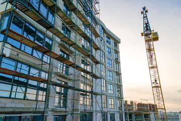 Aerial view of high tower crane and residential apartment buildings under construction. Real estate...
