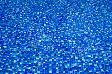 Bright blue swimming pool bottom with clear water surface textured background