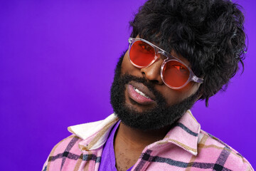 Fashion portrait of african american man in glasses against purple background