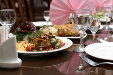 Fried lagman noodles with pieces of meat and vegetables in a plate on the banquet table