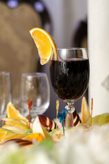 Glass of red wine and a slice of orange fruit snacks on the banquet table
