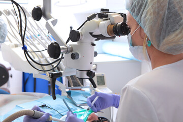 Dental microscope. Treatment of tooth root inflammation. Modern dentistry. Side view. The doctor...
