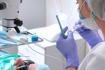 Drill for penetration into the dental canals. The doctor measures the length of the drill....