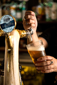 Person pouring a beer in a pub