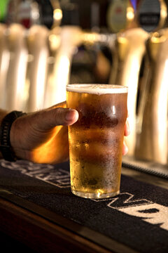 Hand holding a pint of beer