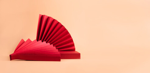 Abstract fashion podium for advertising cosmetics products. Red podium paper oriental fan pink pastel background