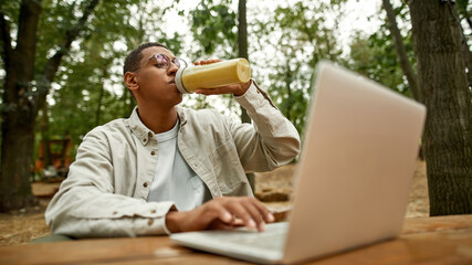 Selective focus on young african american man drinking