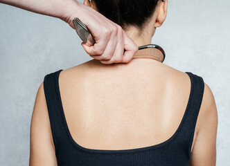 Instrument-assisted soft tissue mobilization, a woman receiving soft tissue treatment on her back...