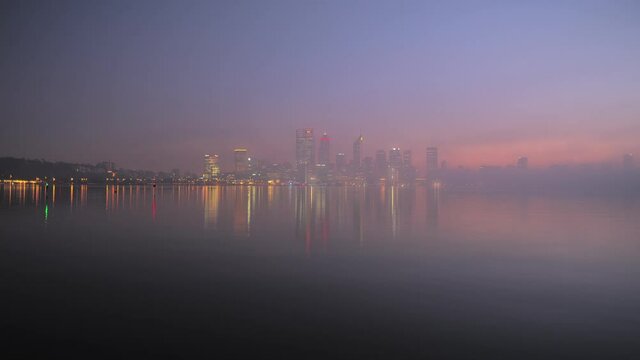 Dawn time lapse Perth City skyline with fog rolling in on the Swan River in Western Australia.