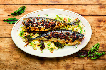 Baked scomber with potatoes,wooden table