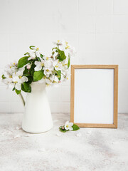 Spring apple blossom in a vase with an empty photo frame