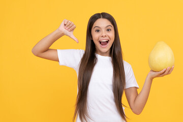 happy child girl hold big citrus fruit of yellow pummelo or pomelo full of vitamin, childhood healt