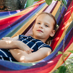 Cute girl in the colorful hammock summer background, summer holiday outdor activities