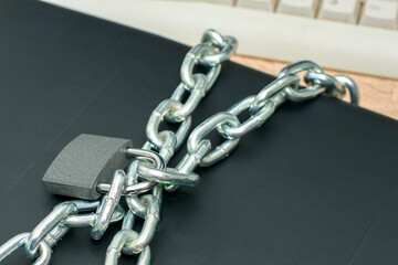 the laptop is wrapped with an iron chain and closed with a padlock the concept of Internet censorship information protection