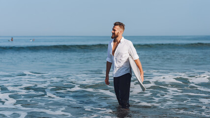 Fototapeta na wymiar .European man with surfboard on the beach in the morning.