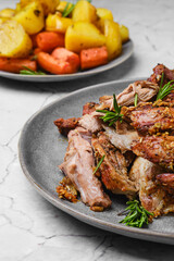 Closeup view of pulled lamb shoulder meat baked in oven with potato and carrot