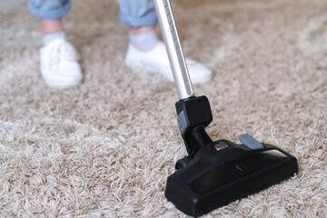cordless vacuum cleaner is used to clean the carpet in the room. Housework with a new handheld...