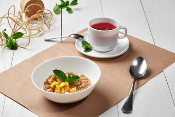 Boiled oatmeal with banana and orange sauce with berry tea