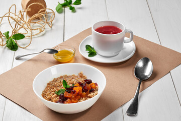 Boiled oatmeal with dried fruits, honey and raspberry tea