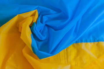 the national flag of Ukraine twisted into a sprial. yellow-blue textured background.