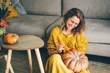 Woman holding the pumpkin and preparing for Halloween.