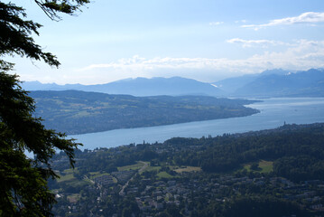 Fototapeta na wymiar Panoramic view over lake Zurich seen from local mountain Uetliberg on a summer day morning. Photo taken June 29th, 2021, Zurich, Switzerland.