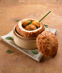 traditional peranakan nonya / malay local cook curry chicken and curry leaf with potato in round big hand made baked bread bun on wood table halal fresh sandwich menu