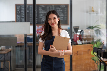 Startup successful small business owner woman beauty girl standing in coffee shop restaurant. Portrait of smiling asian woman barista cafe local owner