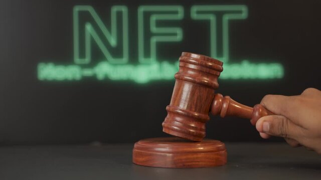 Concept showing of NFT or Non Fungible token Auction or bidding using auction hammer with NFT written on background