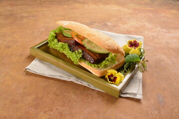 cook kong bak bao asian braised pork belly with vegetables in long focaccia bread and flower salad on wood table asian traditional pastry sandwich menu