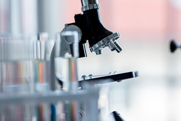 Closeup soft focus of part of microscope with lens in modern scientific laboratory with glass tubes