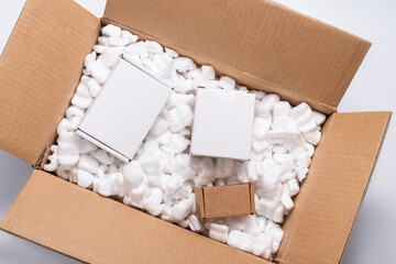 Lot of loose white Filler Shipping Packing Peanuts in cardboard box