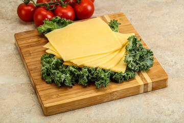 Sliced Gauda cheese over board