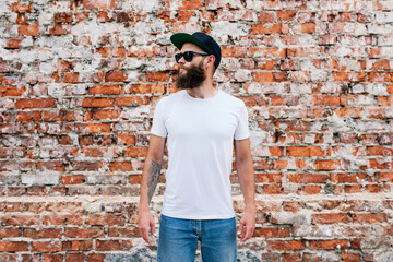 Young bearded hipster guy wearing white blank t-shirt. Mock-up for print. T-shirt template.