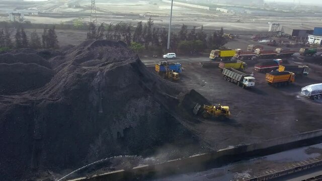 Aerial view around bulldozers and trucks, working at a coal pit - circling, drone shot