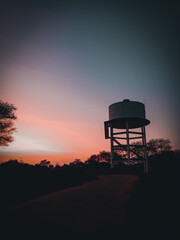 Red evening with water tank in urban area.