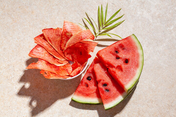 Winter supplies: slices of dried watermelon with fresh pieces on light background with deep shadow