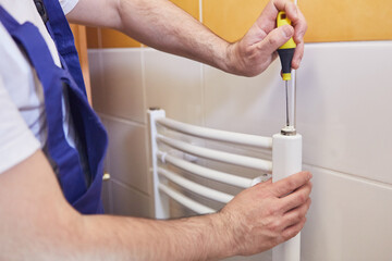 Installateur bei der Montage von Handtuchheizkörper