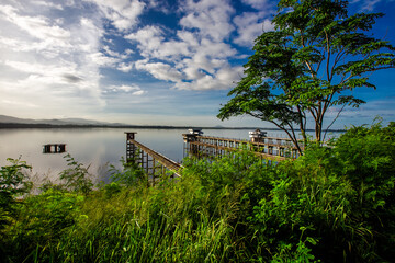 Panoramic natural background of green meadows along the reservoir, surrounding roads and winds and beautiful morning sunlight.